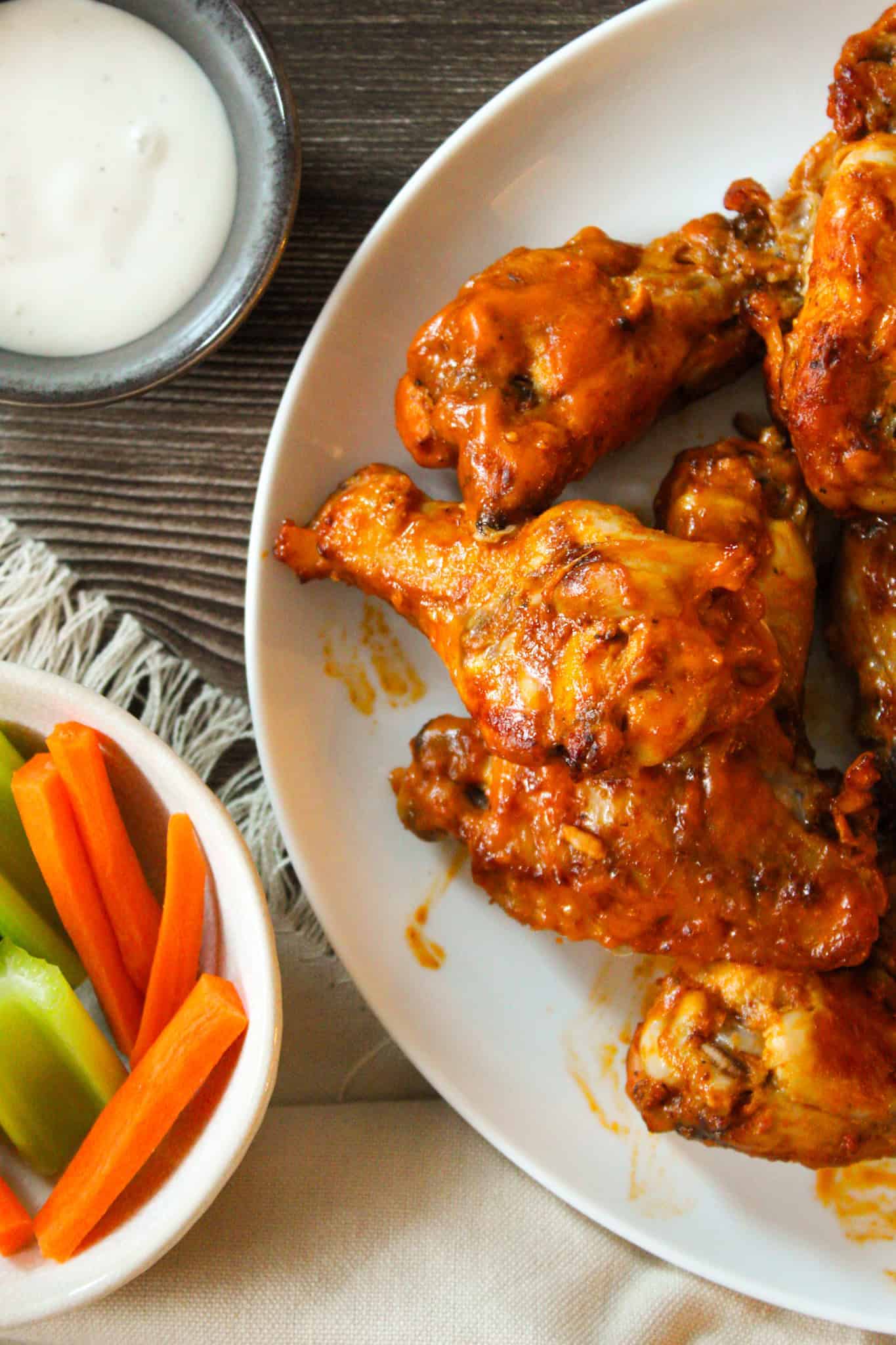 Close up overhead image of chicken wings on a plate.