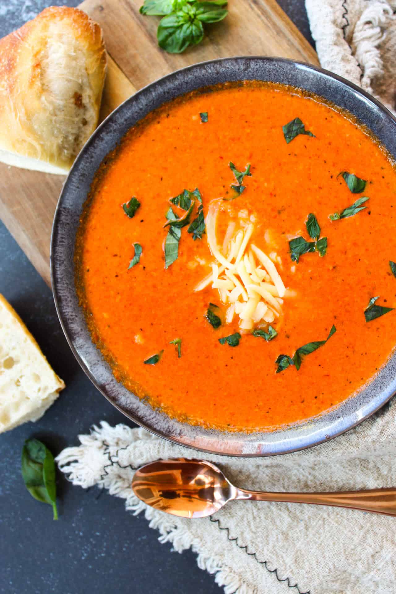 Creamy pepper soup topped with cheese and a crusty piece of bread.