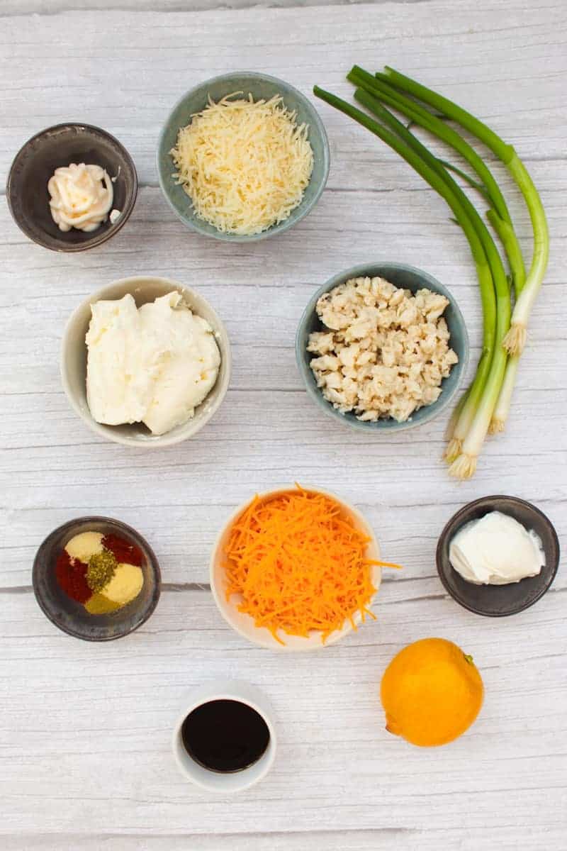 Crab Dip ingredients in separate bowls on a wood surface.