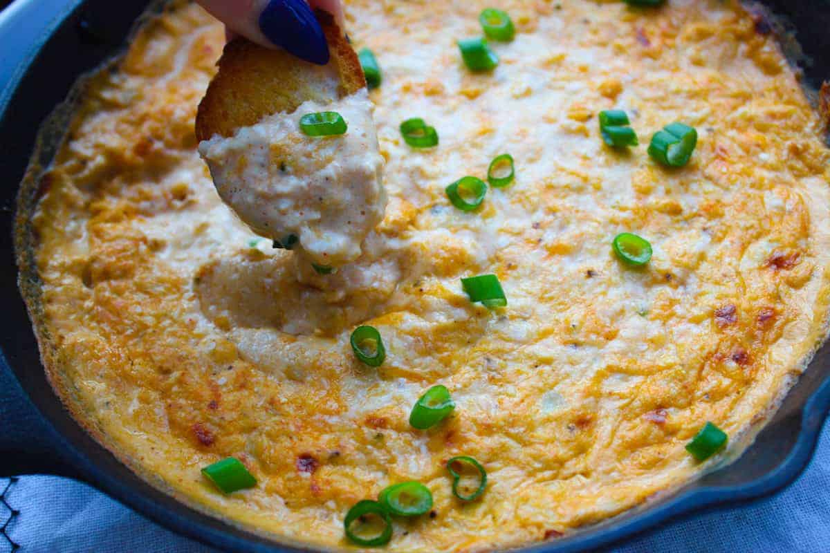 Dipping crusty toast into cajun crab dip. 