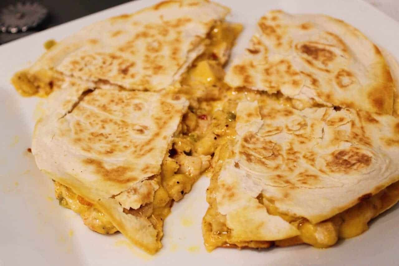 Overhead shot of chicken quesadilla sliced into four pieces.