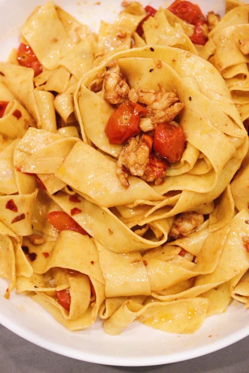 Lobster Pappardelle with lemon butter white wine sauce in a white bowl.