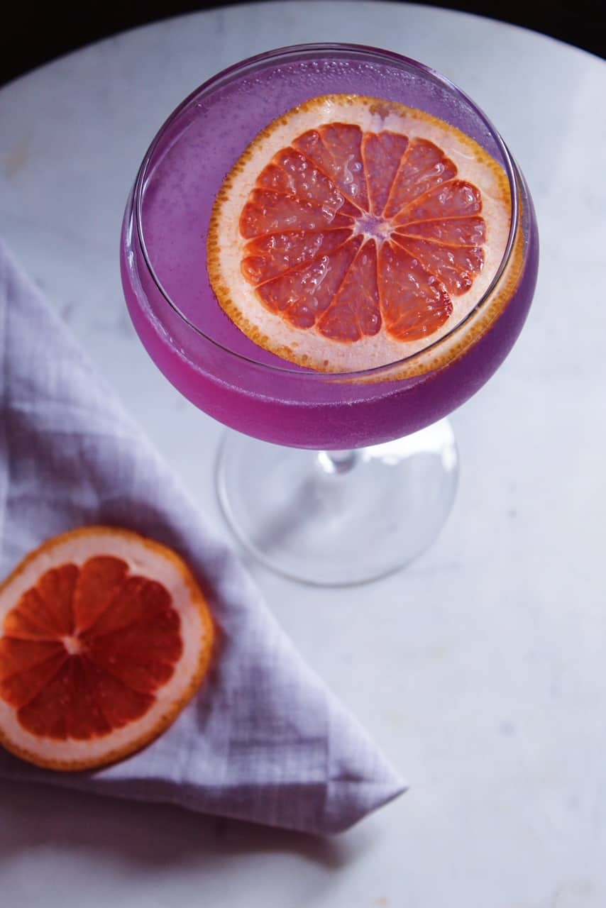 Close up shot from above of pink/purple Grapefruit Empress Gin cocktail. 