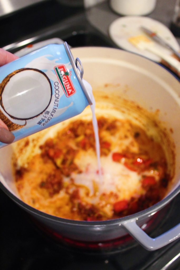 pouring coconut milk into soup