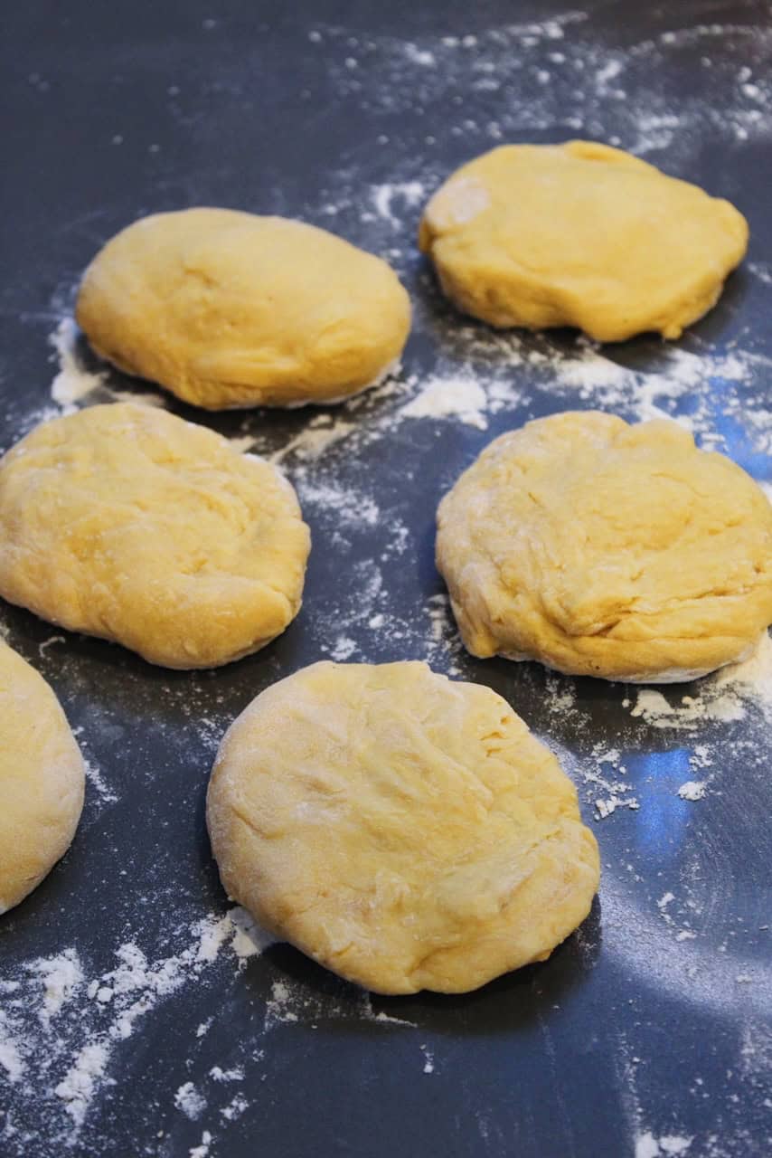 Fresh balls of pasta dough on a grey countertop.