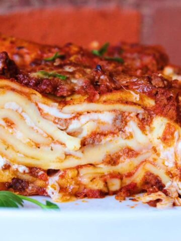 Close up image of layers of cheesy homemade lasagna with fresh noodles.
