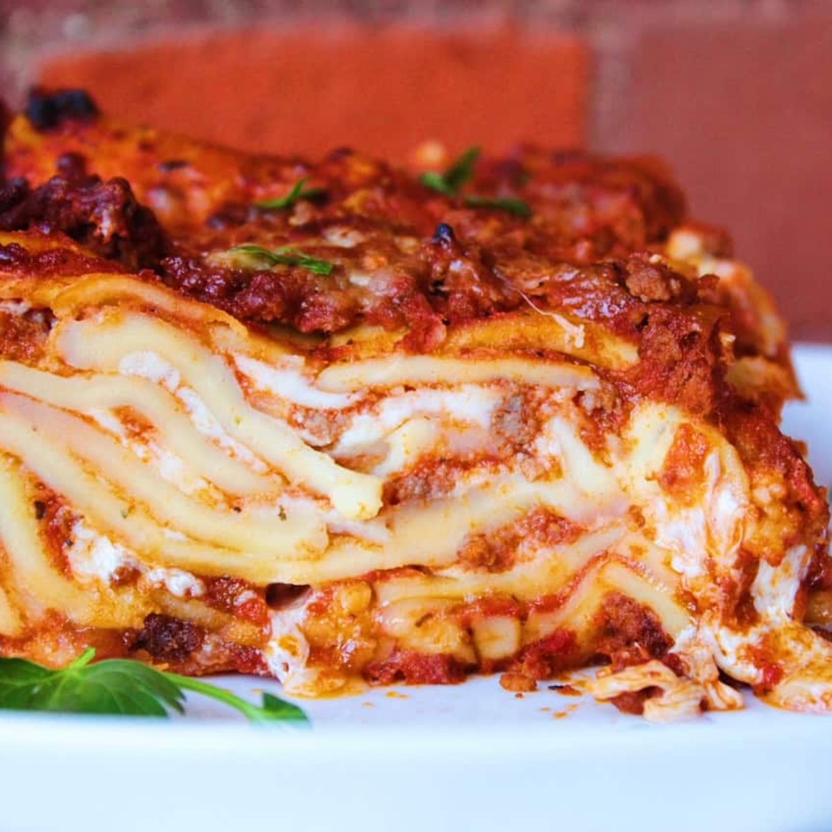 Close up image of layers of cheesy homemade lasagna with fresh noodles.