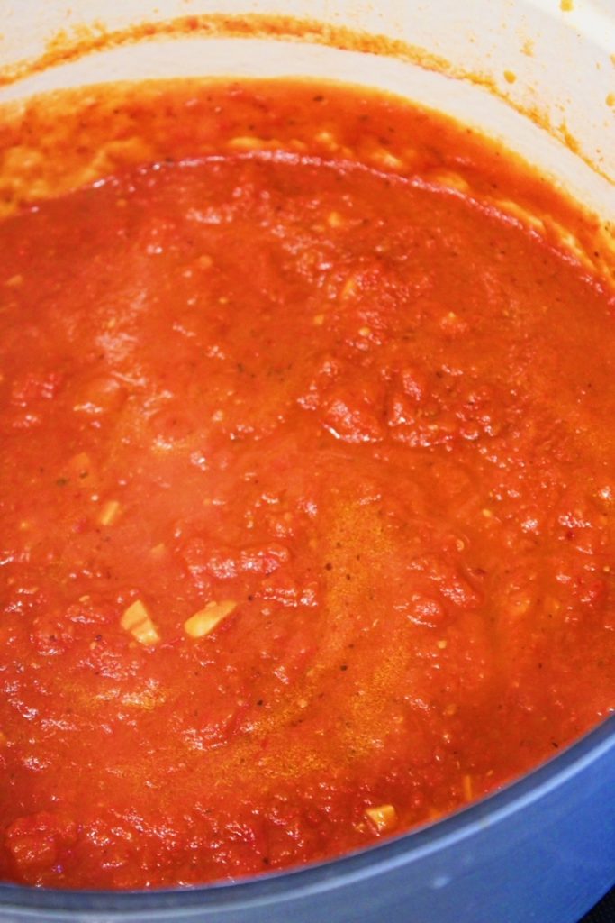 Picture of large pot of arrabbiata sauce simmering.