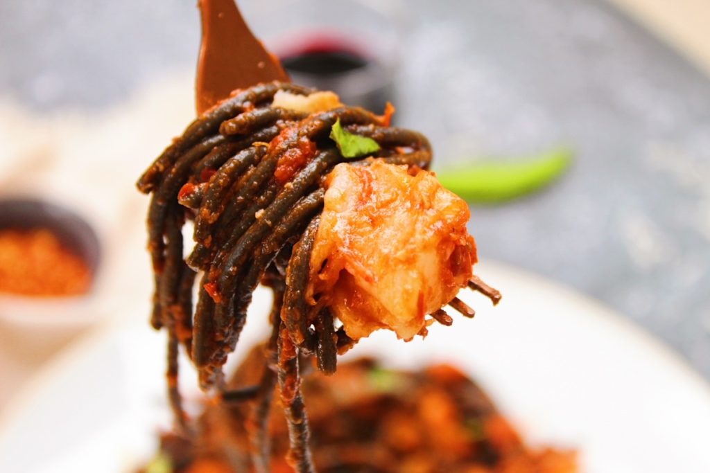 Picture of pasta and shrimp on a copper fork.