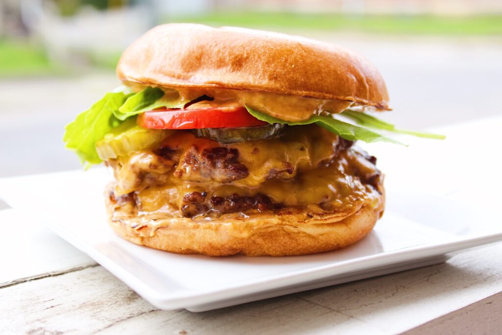 Smash burger with toppings on a bun on a plate.