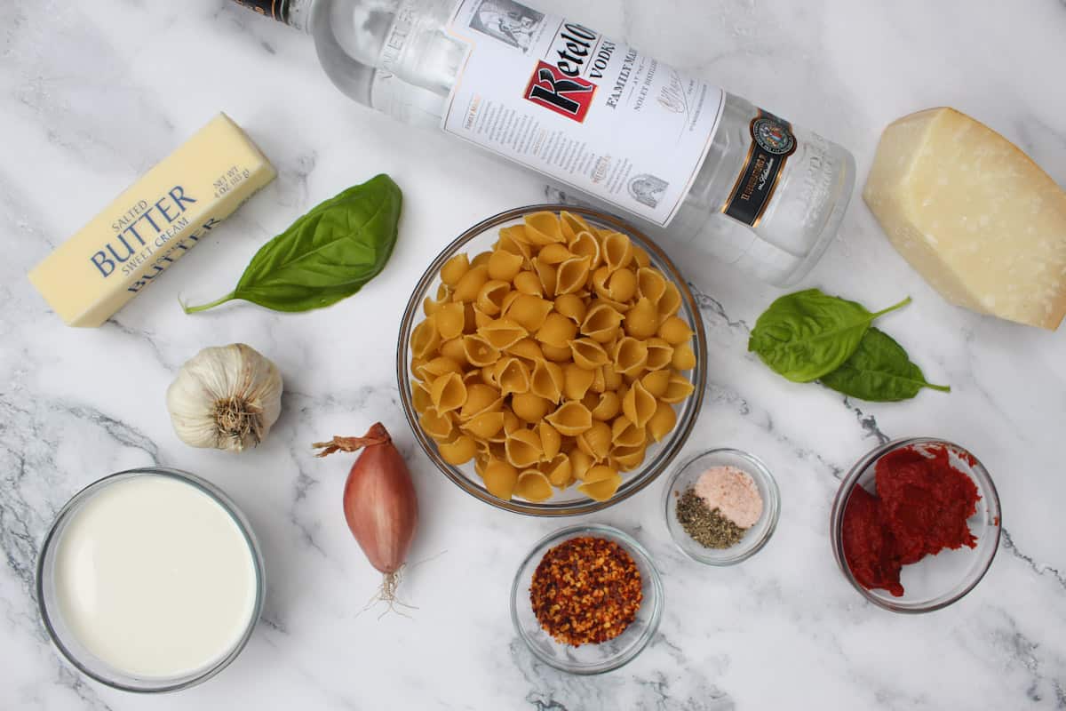 Ingredients for Gigi Hadid Pasta with Spicy Vodka Sauce on marble table.