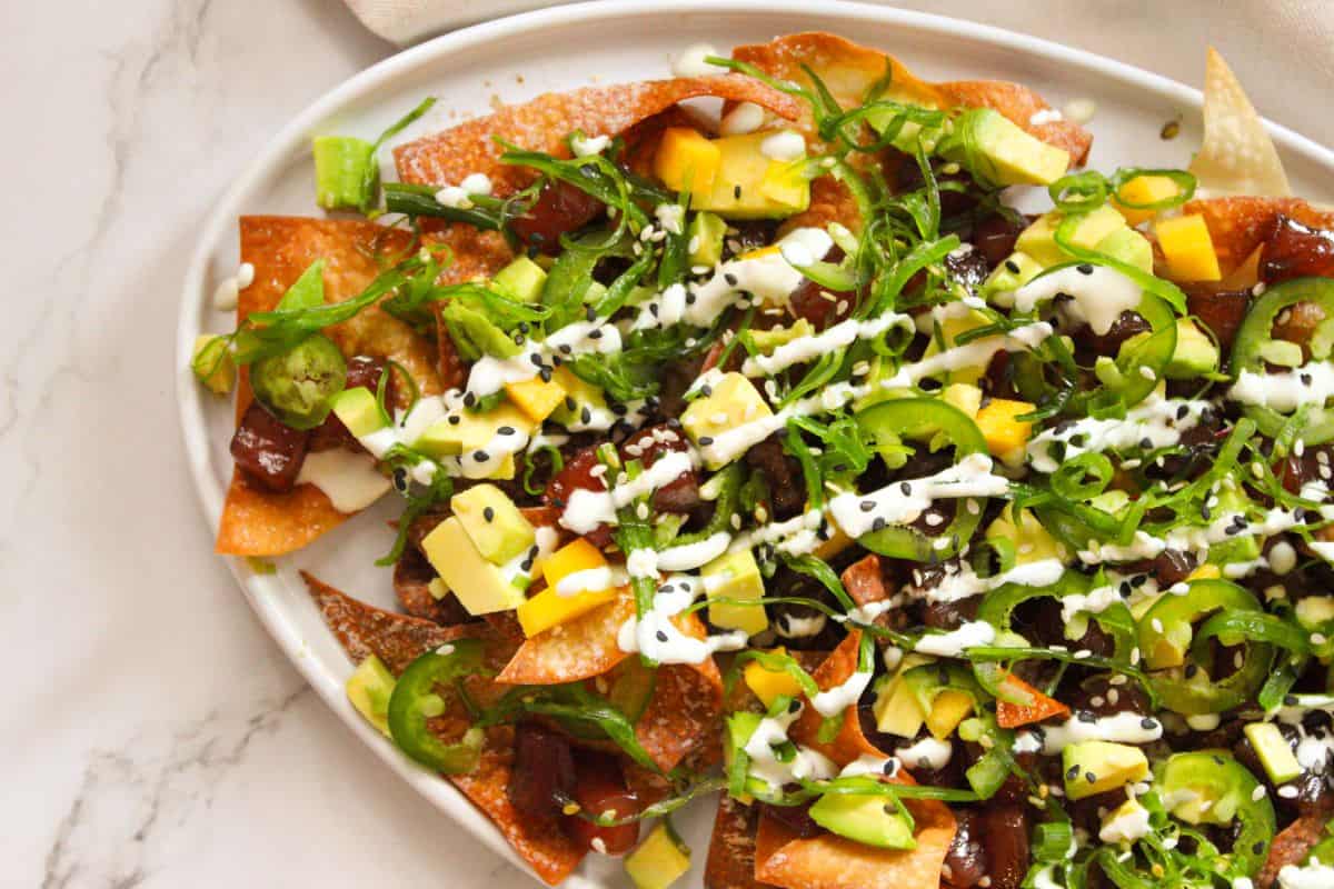 Overhead image of Ahi Tuna Poke Nachos stacked high on a white serving plate.