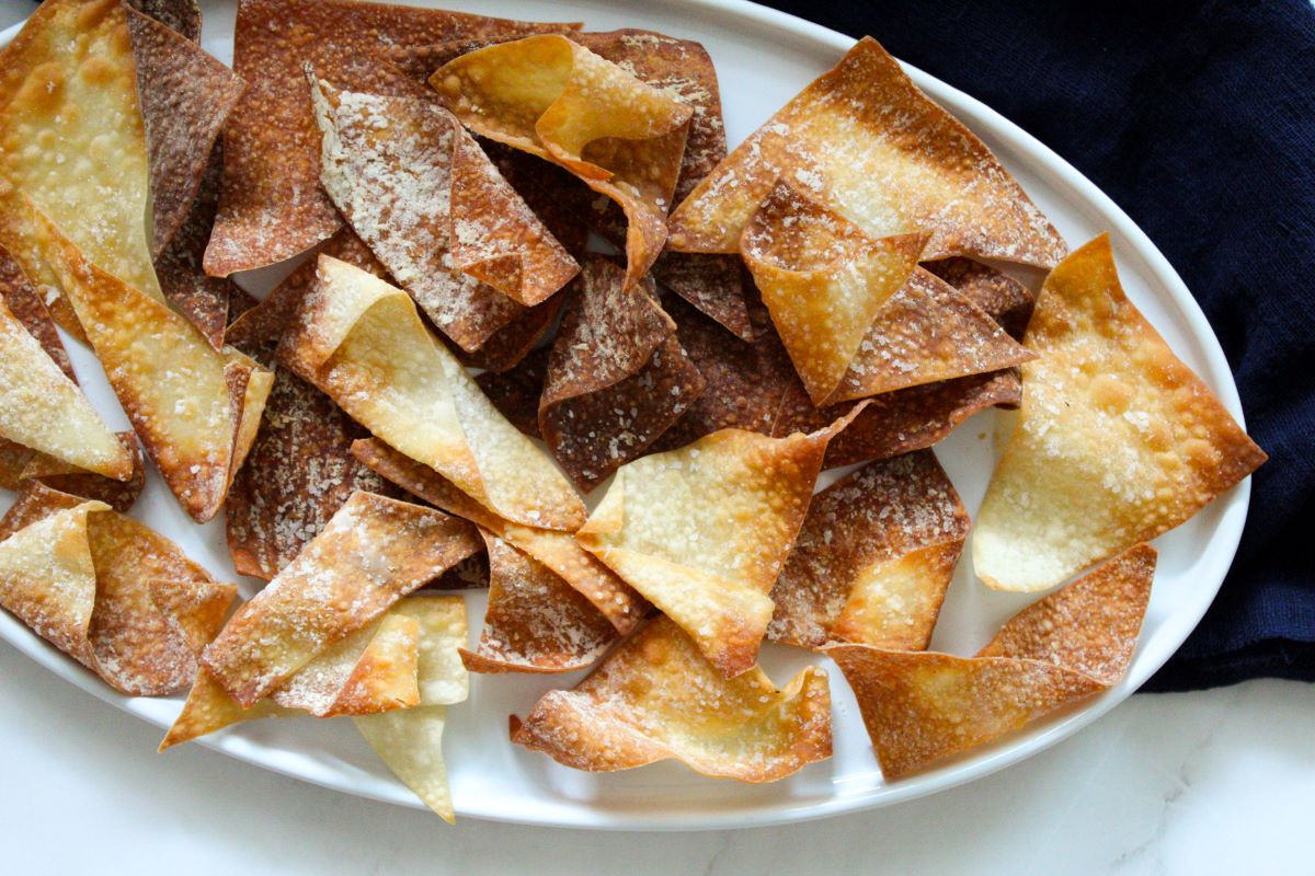 Air fried wonton chips on a white plate.