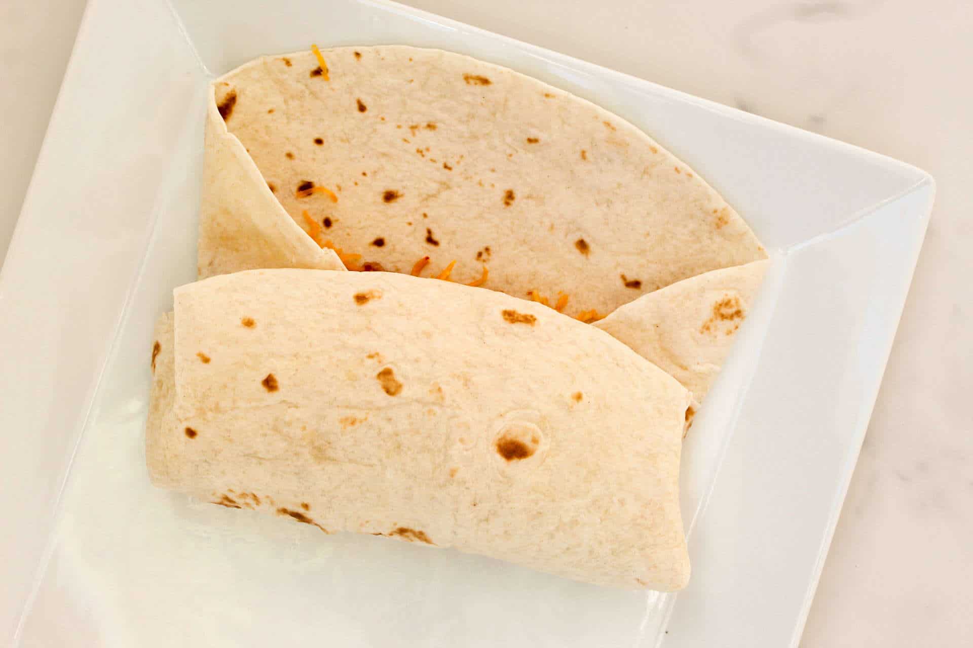 Rolling up tortilla into a burrito.