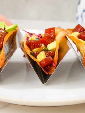 Close up image of Ahi Tuna Tacos (Poke Tacos) n wonton shells with slaw, avocado, and wasabi cream.